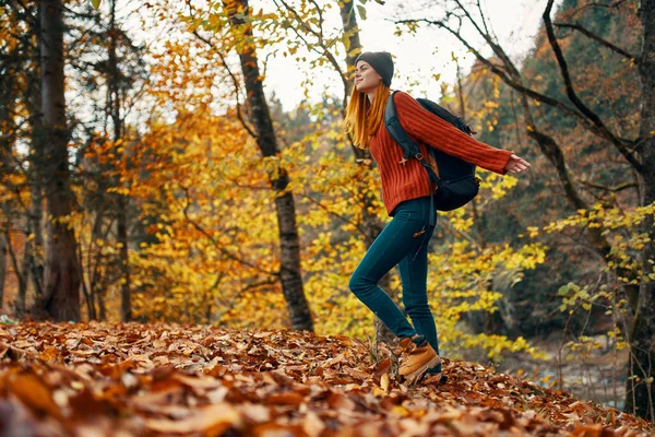Mulher viajante com mochila andando no parque no outono na natureza vista lateral — Fotografia de Stock