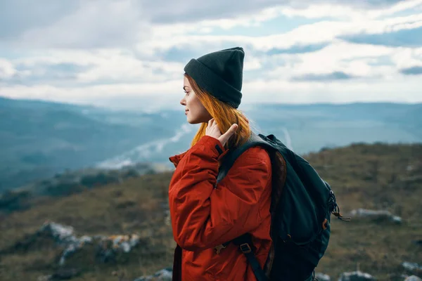 Женщина путешествует в горах пейзаж рюкзак красный пиджак и шляпа модели — стоковое фото