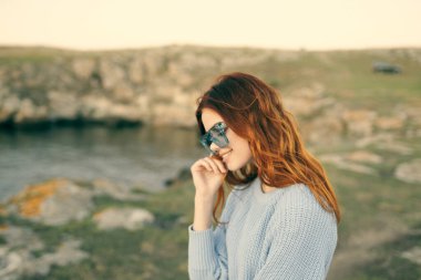 Güzel kızıl saçlı, gözlüklü, temiz hava yolculuğu yapan bir kadın.