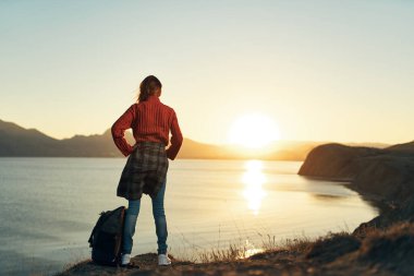 Yükselmiş el manzaralı kadın turist gün batımı tatili