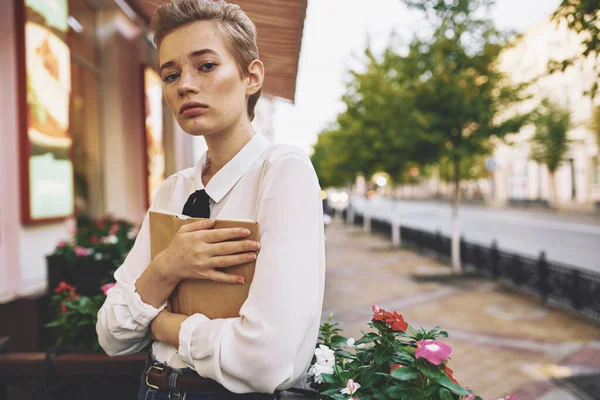 happy woman in shirt short hair model book cafe restaurant street trees