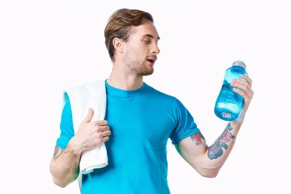 Atleta di sesso maschile in t-shirt blu con un drink in bottiglia e un asciugamano sulla spalla — Foto Stock