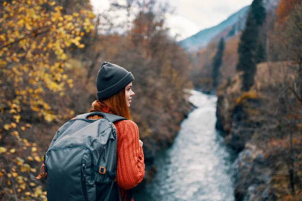 Mujer excursionista con mochila en su espalda cerca del río de montaña en la naturaleza —  Fotos de Stock