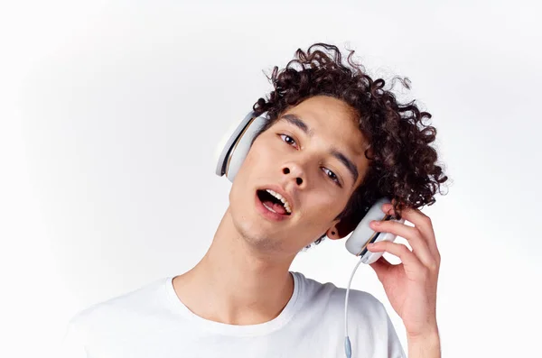 Man met krullend haar dragen hoofdtelefoon muziek emoties close-up — Stockfoto