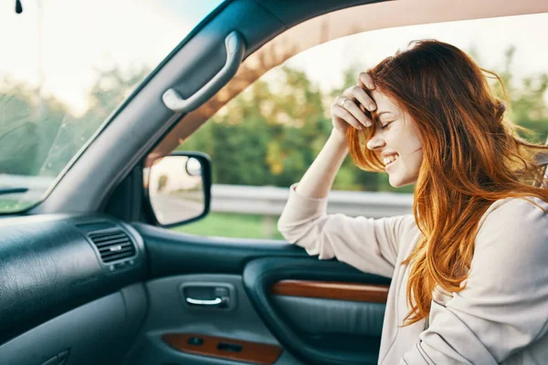 Mujer feliz en suéter de conducción en el asiento delantero de un coche limpio modelo de diseño de interiores — Foto de Stock