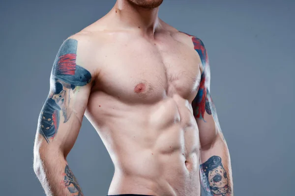 Sexy atleet met naakte romp en opgepompte spieren tattoo grijs achtergrond model — Stockfoto