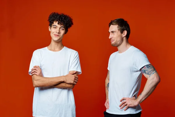 Dos alegres amigos camisetas comunicando aislado fondo amistad — Foto de Stock