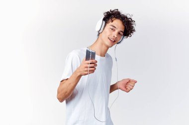 Beyaz tişörtlü duygusal adam kulaklıklı müzik dinliyor.
