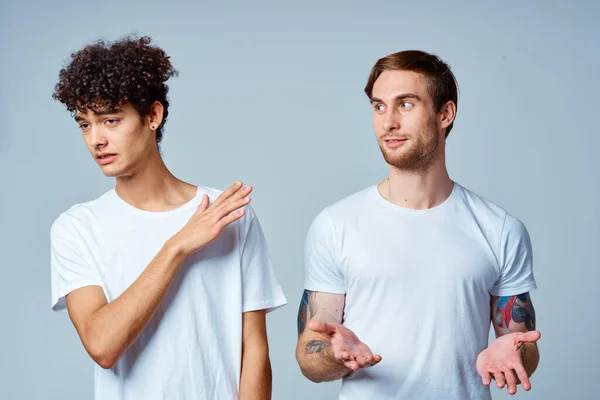 Δύο άντρες με λευκά μπλουζάκια στέκονται δίπλα στα συναισθήματα φιλίας. — Φωτογραφία Αρχείου