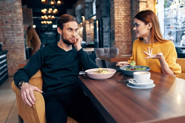 Wesoły młody para siedzi w restauracja odpoczynek jedzenie — Zdjęcie stockowe