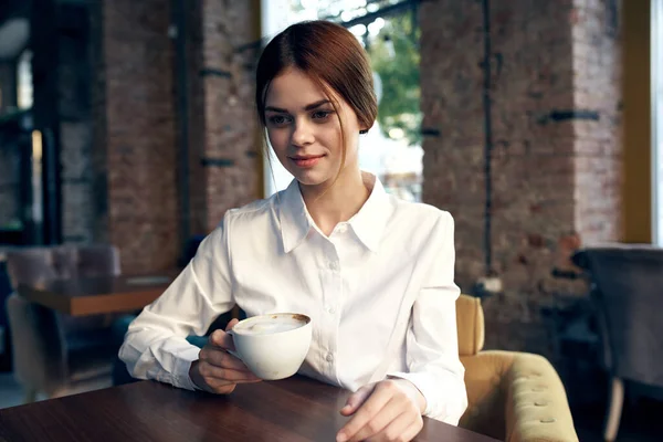 Aranyos üzletasszony ül egy kávézóban az asztalnál egy csésze ital életmód — Stock Fotó