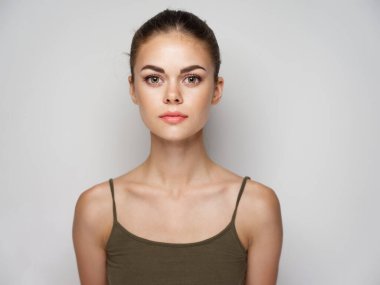 Açık arkaplan saç stili olan tişörtlü güzel bir genç kadın. 