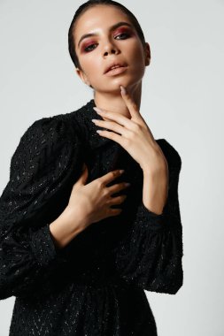 Güzel esmer, parlak makyaj cazibesi siyah elbise modeli.