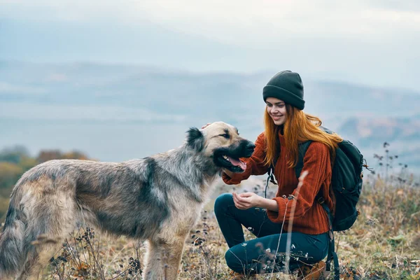 Vrouw wandelaar in de bergen buiten naast de hond reizen — Stockfoto