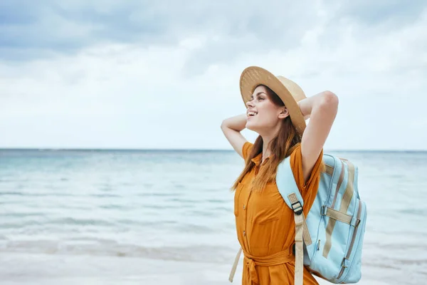 Mujer viajero con mochila cogida de la mano detrás de su cabeza y sombrero de paja modelo turista —  Fotos de Stock