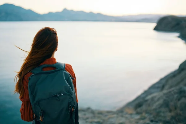 Donna in maglione rosso con zaino e turismo di viaggio mare montagne vista posteriore — Foto Stock