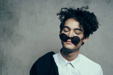 Gözlüklü mutlu adam kıvırcık saçlı, gülümseyen genç. 