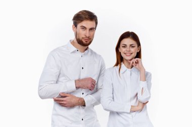 İşteki çalışanlar, arka planda aynı gömlekleri giyen bir kadın ve bir erkek karşı karşıya dururlar.