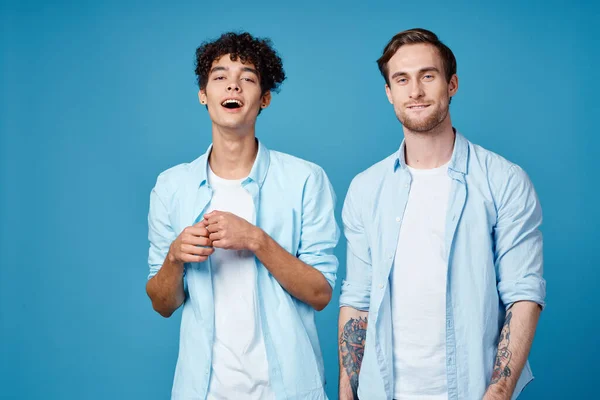 Мужчины в одинаковых футболках и белых футболках на синем фоне болтали друзья обрезанный вид — стоковое фото