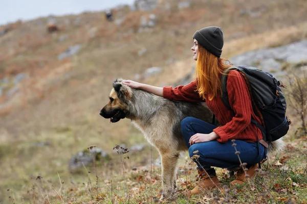 Woman tourist with backpack with dog on nature travel — Stock Photo, Image