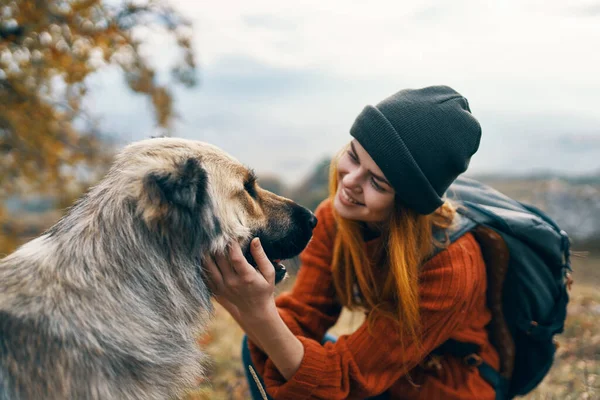 Femme gaie touriste caresser un chien en plein air vacances paysage — Photo