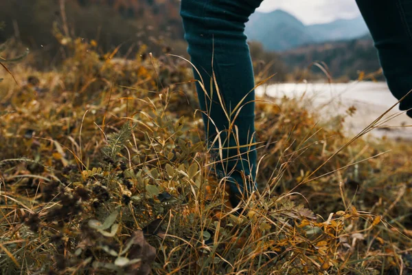 Frauenbeine in Stiefeln und Jeans über die Natur im Herbst in den Bergen — Stockfoto