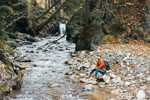 Femme voyageur près d'une rivière de montagne dans la forêt se trouve sur la rive paysage d'automne — Photo