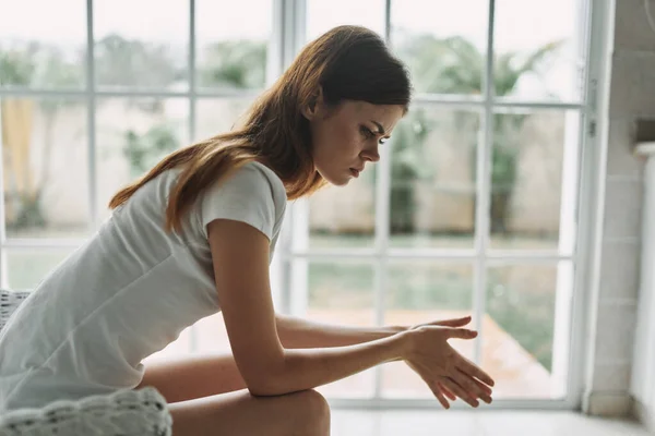 Vrouw thuis zittend op de bank glas in lood raam interieur eenzaamheid — Stockfoto