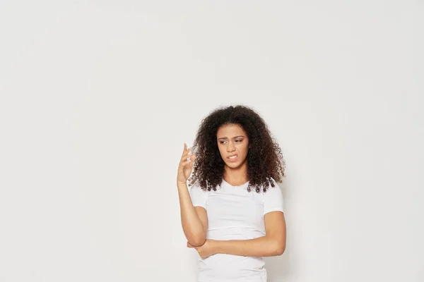 Mujer con el pelo rizado en una camiseta blanca emociones disgusto — Foto de Stock