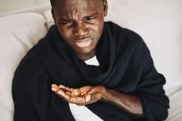 Hombre de aspecto africano en el hogar píldoras frío problemas de salud —  Fotos de Stock
