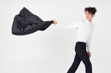  Klasik takım elbiseli genç bir adam. Elinde parlak bir arkaplan olan bir ceket. 