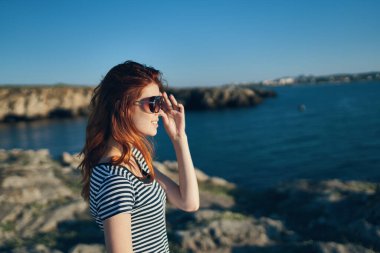 Dağlarda göl kenarında gözlüklü güzel bir kadının portresi.