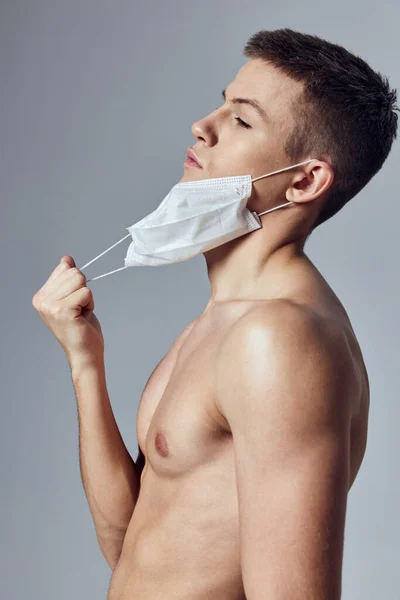 裸の肩の医療マスクの健康保護ワークアウトを持つ男 — ストック写真