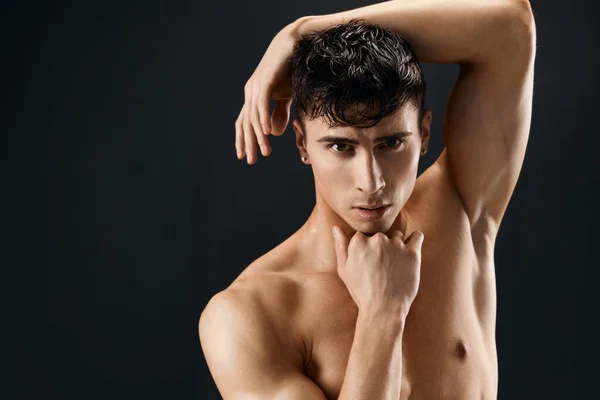 Un uomo attraente con un corpo muscoloso pompato tiene la mano sulla testa primo piano — Foto Stock