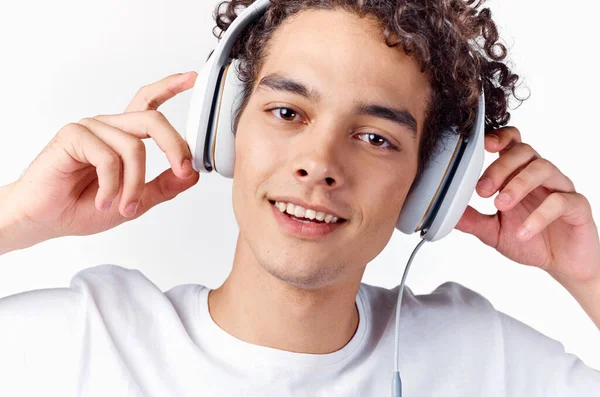 Homem com cabelo encaracolado e em fones de ouvido escuta música — Fotografia de Stock