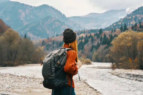 Mulher caminhante com uma mochila descansar nas montanhas na natureza perto do rio — Fotografia de Stock