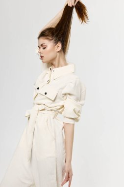 Tulum giymiş çekici bir kadın elleriyle saçlarına dokunuyor.