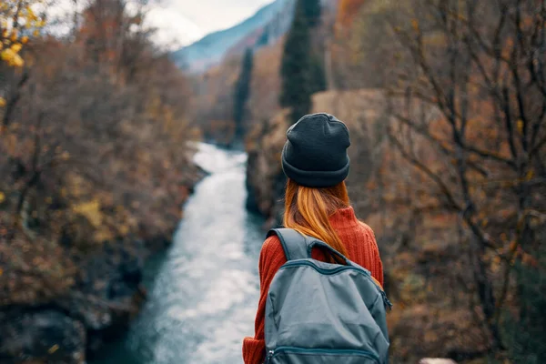 Donna con zaino in natura sul ponte vicino al fiume montagne avventura — Foto Stock