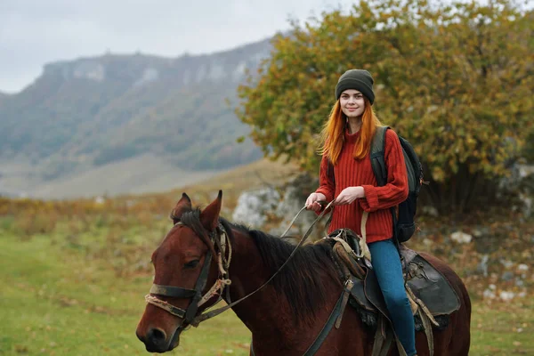 Femme randonneur avec un sac à dos monte un cheval dans la montagne nature Voyage — Photo