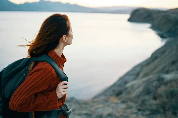 Щасливий мандрівник в светрі і з рюкзаком дивиться на море на відстані і гори природа свіже повітря — стокове фото