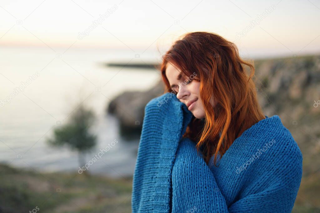 red-haired woman in a blue plaid in the mountains nature fresh air