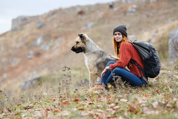 4.快乐的女人在外面的山上散步,旁边跟着狗 — 图库照片