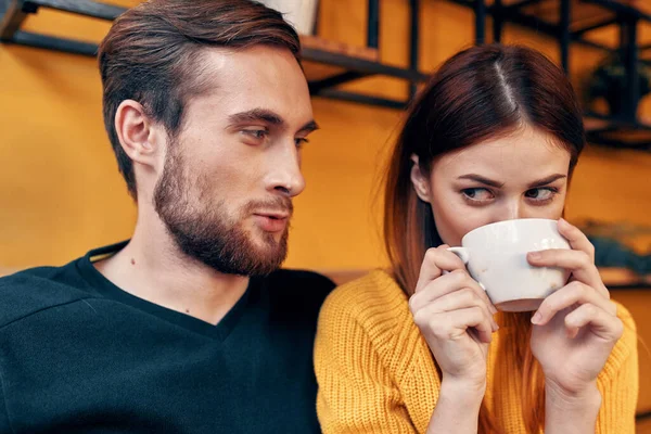 Retrato de um homem em uma camisola e uma mulher com uma xícara de café interior quarto — Fotografia de Stock