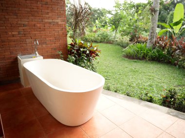 Beyaz banyo, açık bir duvar manzarası olan parlak bir odada ağaçlar taze hava tasarımı.