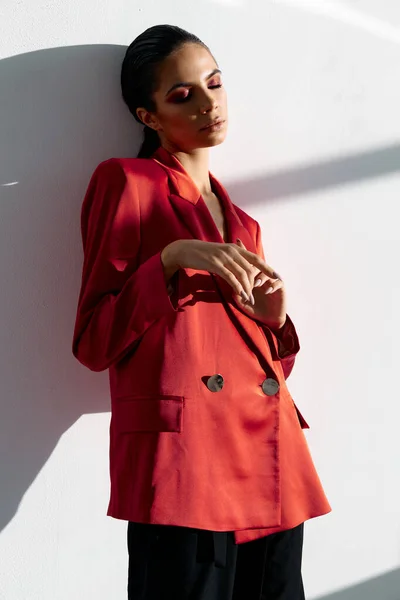 Mulher com olhos fechados jaqueta vermelha moda noite maquiagem luz quarto interior — Fotografia de Stock