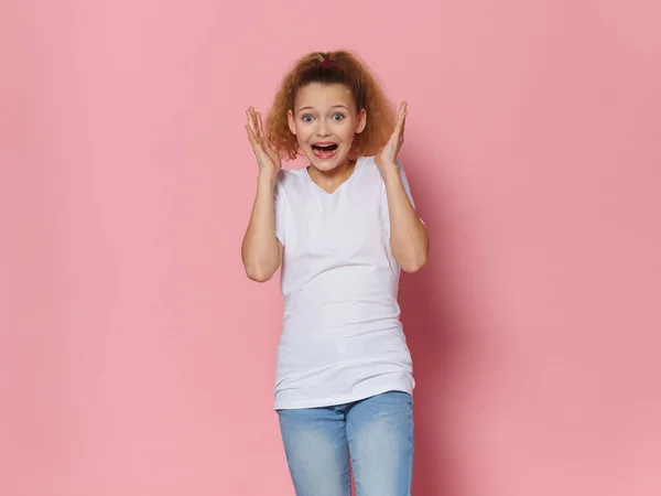 Emotioneel meisje met krullend haar casual kleding roze achtergrond — Stockfoto