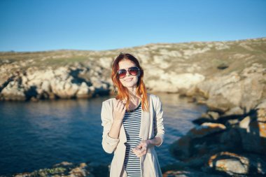 Nehir kenarındaki sahilde dağlarda bir kadın ve şeffaf su sonbahar doğa modeli.