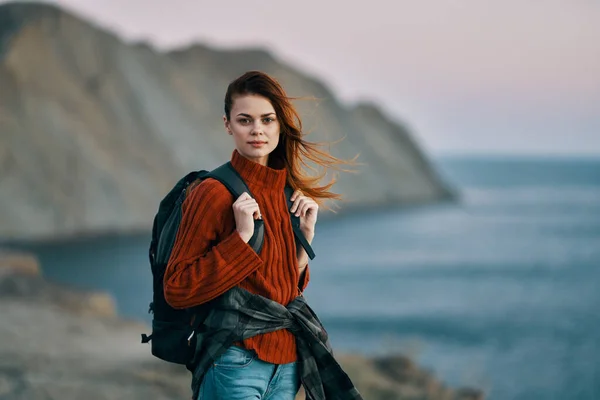 Mujer con mochila en su espalda viaje turismo suéter océano mar montañas — Foto de Stock
