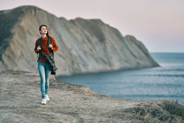 Woman with backpack sweater mountains sea nature fresh air — Stock Photo, Image