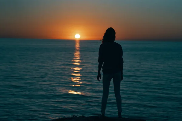 Femme au coucher du soleil silhouette de mer sur le rivage — Photo